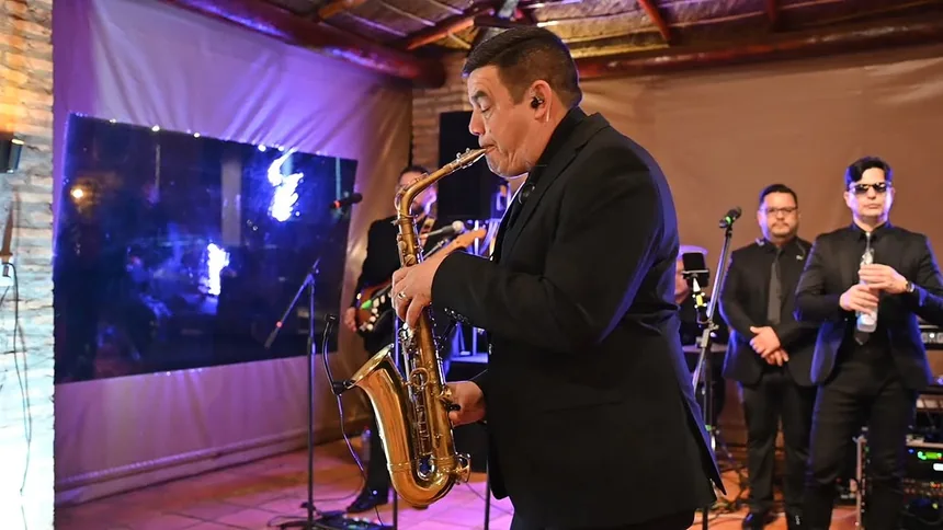 Saxofonista de Mandu'arã tocando en un salón, con el grupo detrás
